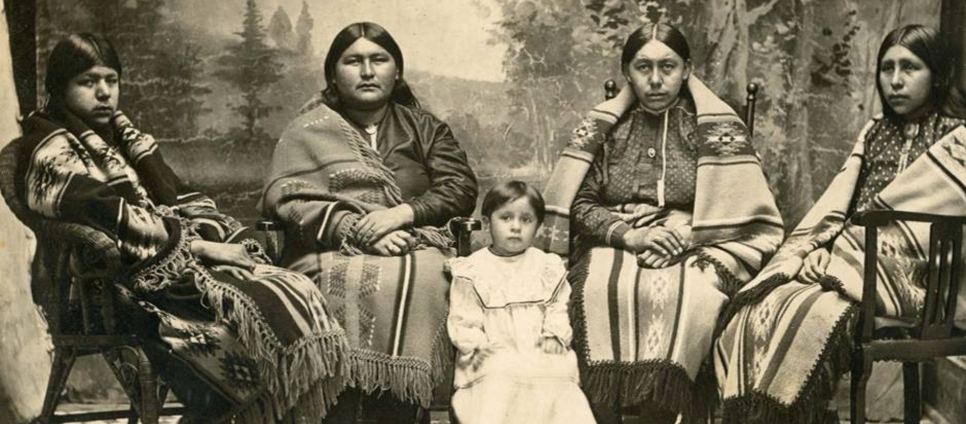 The following real photo postcard depicts four Osage women and a young child from around 1910. The woman second from the right was Louise Tuman, wife of Chief Black Dog.