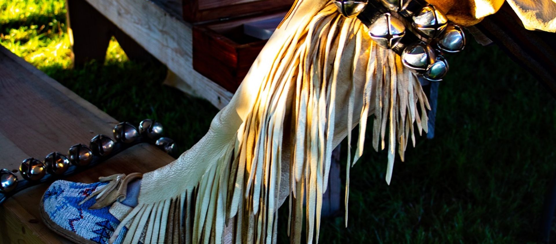 Wahzhazhe man ties on his bells over ultra suede and fully beaded moccasins.