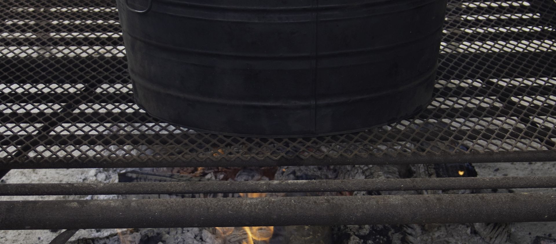 Dumplings being cooked over an outdoor fire. 