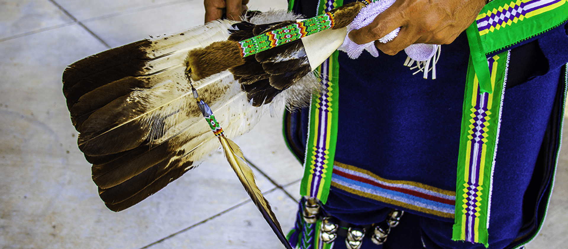 Wahzhazhe man carries an eagle feather fan and beaded stick. Traditionally, only tail dancers carried sticks. You will also see some men carry mirrors, axes and other cultural items specific to their clans. 