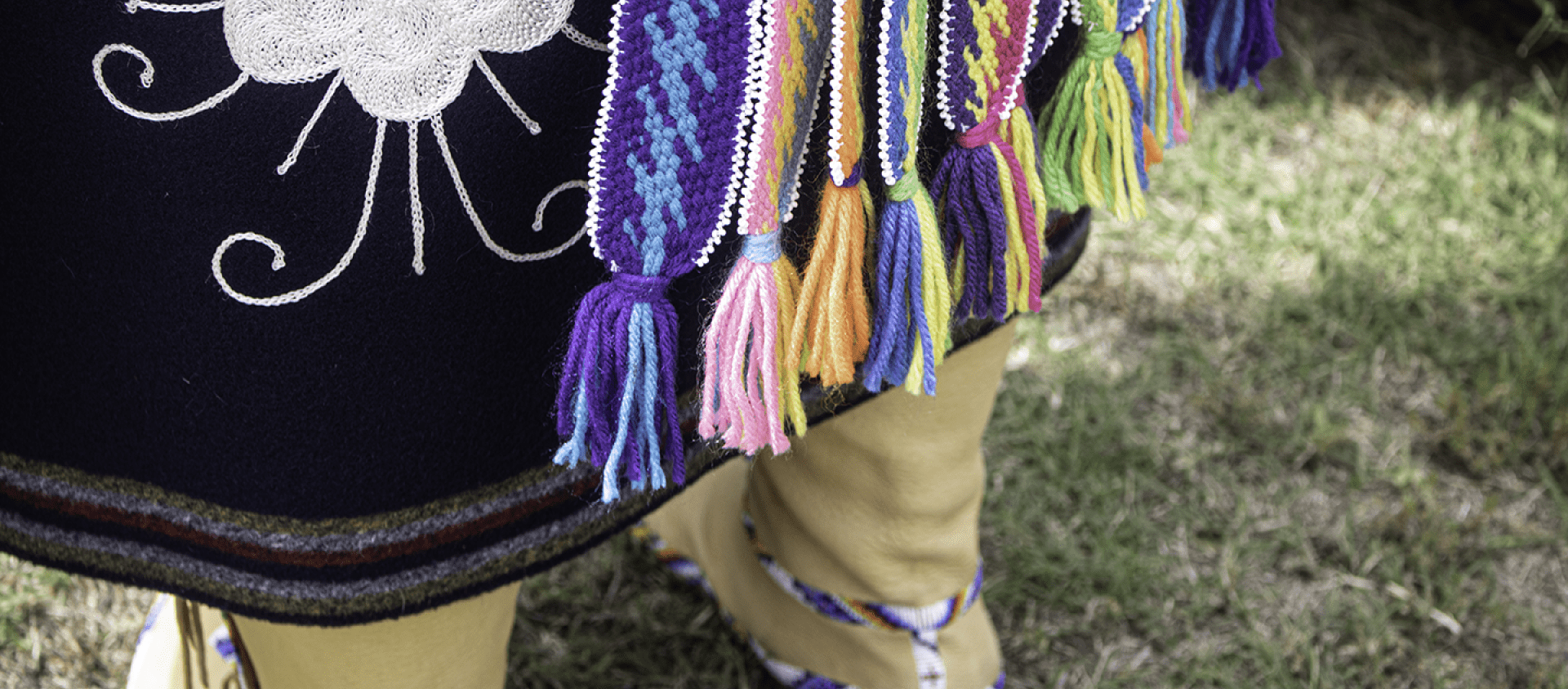 Embroidered broadcloth skirt with lightning patterned fingerweaving. The hang downs are edged with beading. 