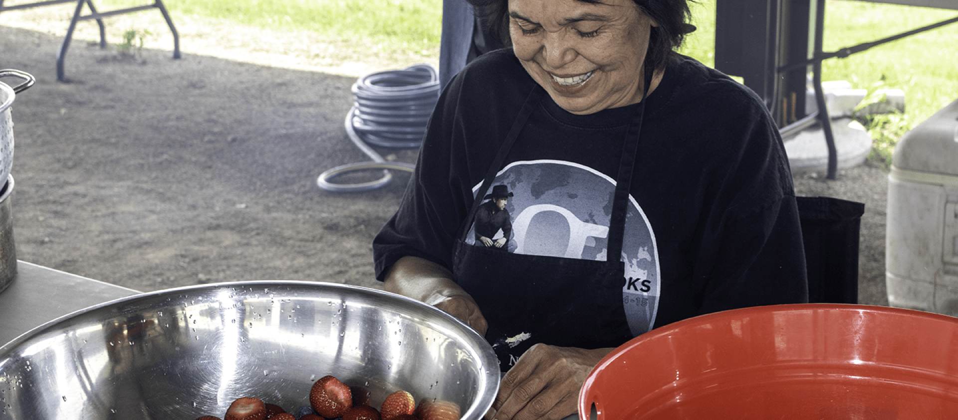 Wahzhazhe cook cuts fruit during Grayhorse Inlonshka (2022). 