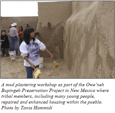 Image shows a youth member plastering a wall during a workshop in New Mexico